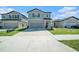 Charming two-story home with an attached garage, manicured lawn, and neutral-colored exterior with a driveway at 35542 Buttonweed, Zephyrhills, FL 33541