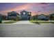 Exterior view of two-story home at dusk, featuring a landscaped front yard and ample driveway space for parking at 35542 Buttonweed, Zephyrhills, FL 33541