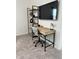 A well-lit home office with a modern desk, shelving, and a wall-mounted TV for a productive and enjoyable workspace at 35542 Buttonweed, Zephyrhills, FL 33541