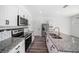 Modern kitchen with stainless steel appliances, granite countertops, and a spacious island with a double sink at 35542 Buttonweed, Zephyrhills, FL 33541