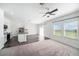 Open concept living room featuring hardwood floors, natural lighting, a ceiling fan, and modern kitchen view at 35542 Buttonweed, Zephyrhills, FL 33541