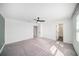Bright and spacious main bedroom with plush carpeting, ceiling fan, and access to a bathroom at 35542 Buttonweed, Zephyrhills, FL 33541