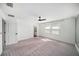 Bright main bedroom with plush carpet, large windows, and a ceiling fan at 35542 Buttonweed, Zephyrhills, FL 33541