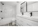Modern bathroom with marble-look tile, dual sink vanity, and sleek black fixtures at 3639 Richboro Dr, Holiday, FL 34691