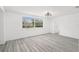 Bright bedroom with gray wood-look floors, a modern light fixture, and a large window with natural light at 3639 Richboro Dr, Holiday, FL 34691