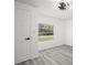 Bright bedroom with gray wood-look floors and a view to the outdoors through a large window at 3639 Richboro Dr, Holiday, FL 34691