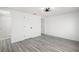 Bedroom featuring gray wood-look floors and a doorway to a luxurious bathroom at 3639 Richboro Dr, Holiday, FL 34691