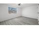 Bedroom featuring gray wood-look floors, modern light fixture, and a window providing natural light at 3639 Richboro Dr, Holiday, FL 34691