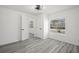 Bright bedroom with gray wood-look floors, featuring an open door to another room at 3639 Richboro Dr, Holiday, FL 34691