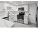Modern kitchen with white cabinets, stainless steel appliances, and quartz countertops at 3639 Richboro Dr, Holiday, FL 34691