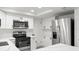 Modern white kitchen features stainless steel appliances, quartz counters, and custom cabinets at 3639 Richboro Dr, Holiday, FL 34691