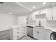 Modern kitchen with white cabinets, stainless steel appliances, quartz countertops, and gray vinyl flooring at 3639 Richboro Dr, Holiday, FL 34691