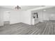 Bright and open living space with gray wood-look floors and a modern light fixture at 3639 Richboro Dr, Holiday, FL 34691