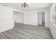 Bright and open living space featuring gray wood-look floors, white walls, and a modern light fixture at 3639 Richboro Dr, Holiday, FL 34691