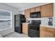 Bright kitchen featuring black appliances, wood cabinets, tile floor and a window at 4106 Waterside Island Ct, Tampa, FL 33617
