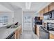 Well-lit kitchen featuring black appliances, wood cabinets, tile floor and a stainless steel sink at 4106 Waterside Island Ct, Tampa, FL 33617