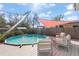A pool is surrounded by a deck and lounge furniture, shaded by a sunshade at 4346 10Th N Ave, St Petersburg, FL 33713