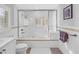 Bright white bathroom showcasing a glass-enclosed shower and tub with classic white tile at 4514 W Beachway Dr, Tampa, FL 33609