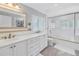 Bright bathroom with double sinks, white cabinets, and a shower over tub combination at 4514 W Beachway Dr, Tampa, FL 33609