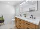 Bright bathroom featuring a double sink vanity, large mirror, and plantation shutters at 4514 W Beachway Dr, Tampa, FL 33609