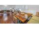 Open-concept dining area with a large wooden table and bench seating, flowing seamlessly from the living room at 4514 W Beachway Dr, Tampa, FL 33609