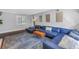 Comfortable living room featuring a blue sectional sofa, a patterned rug, and hardwood floors at 4514 W Beachway Dr, Tampa, FL 33609
