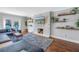 Bright living room featuring a stone fireplace, a blue sofa, and wooden shelves with decorative items at 4514 W Beachway Dr, Tampa, FL 33609