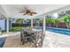 Relaxing covered patio with a dining table, ceiling fan, and backyard pool view at 4514 W Beachway Dr, Tampa, FL 33609