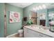 Bathroom featuring a double sink vanity, soft green walls, a toilet, and a large, decorative mirror at 5100 Cedarbrook, Hernando Beach, FL 34607