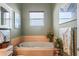 Bathroom featuring a garden tub with a tile surround, flower decor and a window providing natural light at 5100 Cedarbrook, Hernando Beach, FL 34607