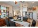 Bright dining room featuring a glass-top table, black chairs, and a partial view of the modern kitchen at 5100 Cedarbrook, Hernando Beach, FL 34607