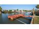 Wide angle view of a red wooden dock and pier stretching out onto the canal with waterfront homes in the distance at 5100 Cedarbrook, Hernando Beach, FL 34607