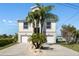 The home features a two-car garage and a well-manicured front yard with rock landscaping and palm trees at 5100 Cedarbrook, Hernando Beach, FL 34607