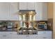 Close-up of the kitchen with stainless steel range and hood with white cabinets at 5100 Cedarbrook, Hernando Beach, FL 34607