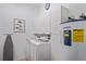 Laundry room featuring a washer, dryer, water heater, storage cabinets, and an ironing board at 5100 Cedarbrook, Hernando Beach, FL 34607