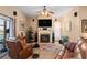 Cozy living room with a fireplace, ceiling fan, comfortable seating, and a sliding door leading to the porch at 5100 Cedarbrook, Hernando Beach, FL 34607