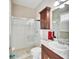 Bathroom with shower and bath, cabinet sink, and red towels at 5115 Abisher Wood Ln, Brandon, FL 33511