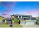 Elegant two-story home featuring stone accents, a three-car garage, and a well-manicured front lawn at 5115 Abisher Wood Ln, Brandon, FL 33511