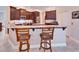 Stylish kitchen featuring dark wood cabinets, granite countertops, and modern stainless steel appliances at 5115 Abisher Wood Ln, Brandon, FL 33511