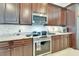 Well-equipped kitchen features granite counters, stainless steel appliances, and dark wood cabinetry at 5115 Abisher Wood Ln, Brandon, FL 33511