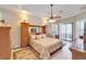 Spacious main bedroom features tray ceiling, ceiling fan, and sliding glass door to patio at 5115 Abisher Wood Ln, Brandon, FL 33511