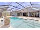 Backyard view of screened-in pool and spa with water feature at 5115 Abisher Wood Ln, Brandon, FL 33511