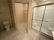 Bathroom with glass-enclosed shower, toilet, and shelving in walk-in closet at 5125 Palm Springs Blvd # 1203, Tampa, FL 33647