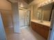 Bathroom featuring glass-enclosed shower, vanity, mirror, and walk-in closet at 5125 Palm Springs Blvd # 1203, Tampa, FL 33647