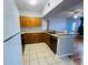 Efficient kitchen with wood cabinetry, black appliances, and breakfast bar overlooking living area at 5125 Palm Springs Blvd # 1203, Tampa, FL 33647