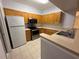 Well-lit kitchen featuring wood cabinetry, modern appliances and light countertops at 5125 Palm Springs Blvd # 1203, Tampa, FL 33647