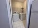 A convenient laundry room features a side-by-side washer and dryer set on white tile flooring at 5125 Palm Springs Blvd # 1203, Tampa, FL 33647
