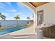Beautiful waterfront view from the outdoor seating area featuring an in-ground pool and luscious green landscape at 5128 W Longfellow Ave, Tampa, FL 33629