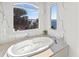 Inviting soaking tub nestled beneath a large window with scenic water views at 5128 W Longfellow Ave, Tampa, FL 33629