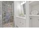 Elegant bathroom with a glass-enclosed shower and a white vanity with ample storage space at 5128 W Longfellow Ave, Tampa, FL 33629